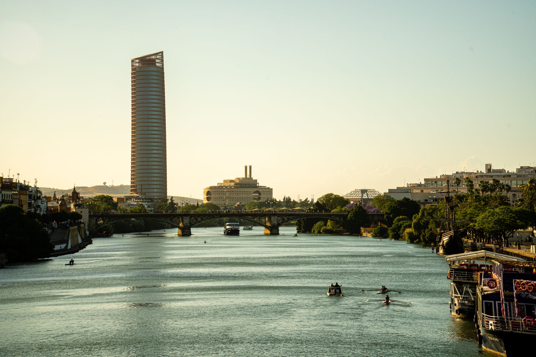 Vue du Guadalquivir et des ponts de Séville au coucher du soleil avec la ville en arrière-plan