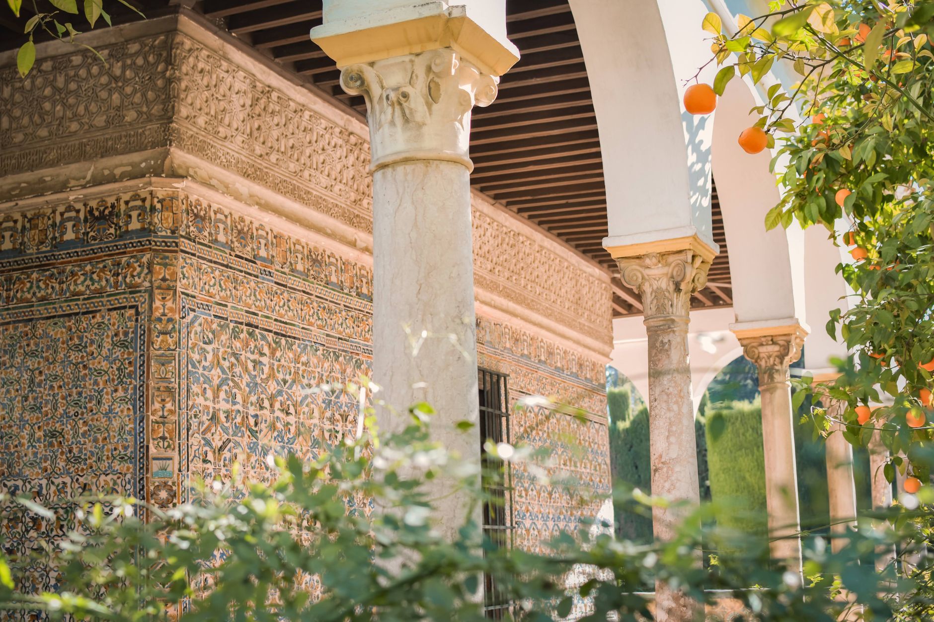 Vue des jardins de l'Alcázar de Séville avec ses colonnes ornementales et ses carreaux de céramique